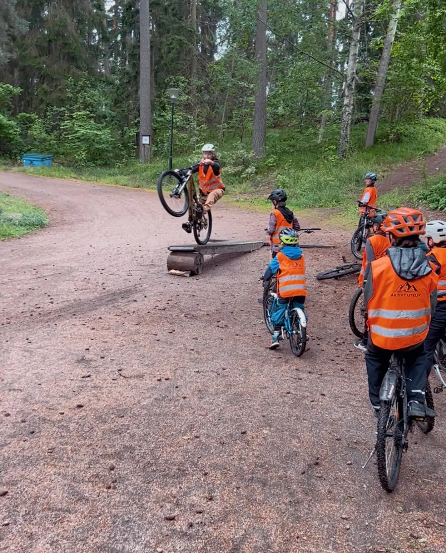 Kinder im MTB-Camp üben vor der Gruppe Balance und Fahrtechnik