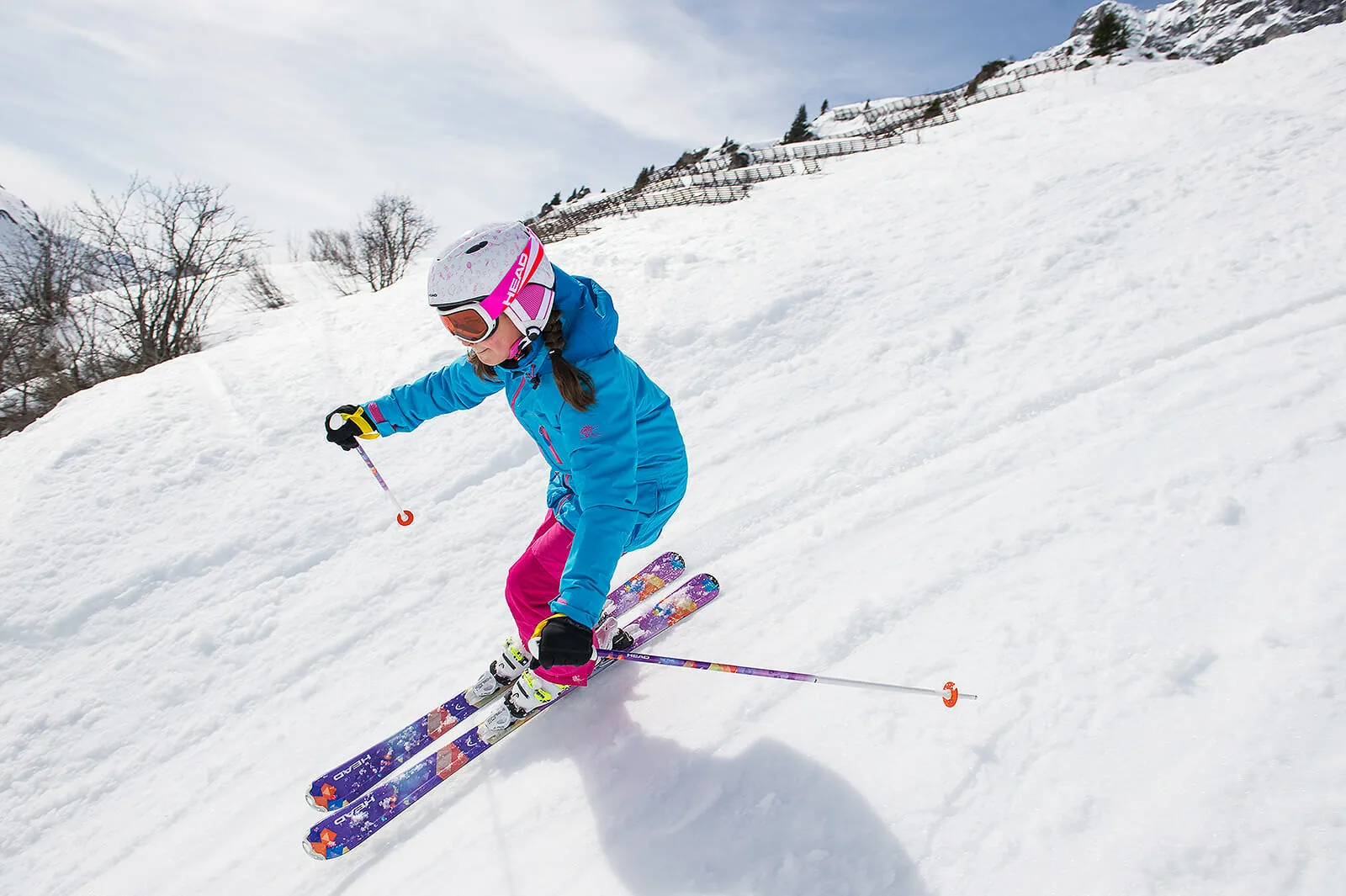 Barn med hjälm som åker alpina skidor